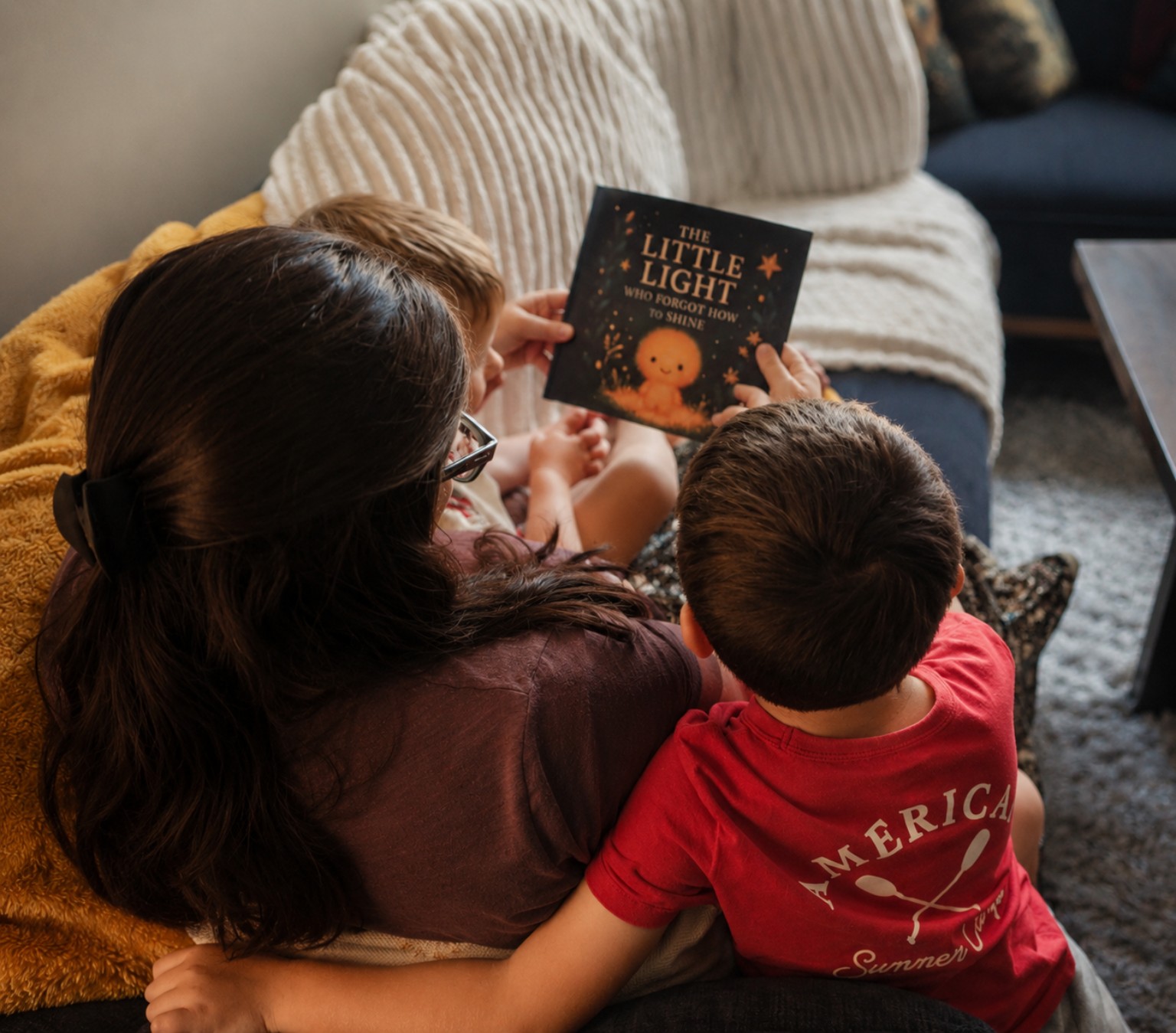 A mother sharing The Little Light Who Forgot How to Shine with two children